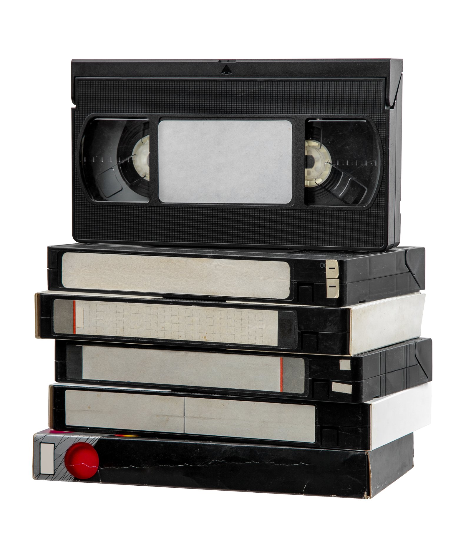 A pile of VHS video cassettes on a plain white background